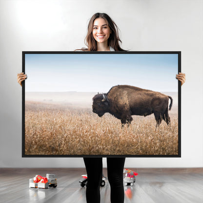 A majestic bison standing in an open prairie field, its strong form blending into the golden grass under a vast blue sky, evoking the wild spirit of the American plains.
