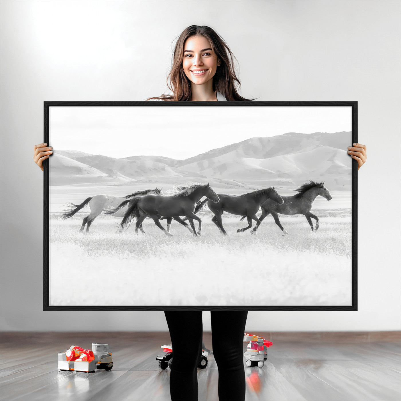 A black and white image of wild horses running freely across an open grassland, capturing the power and beauty of untamed nature in a rustic western setting.