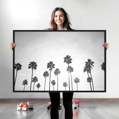 A black and white minimalist scene featuring tall palm trees silhouetted against a bright sky, creating a dreamy and timeless tropical aesthetic.