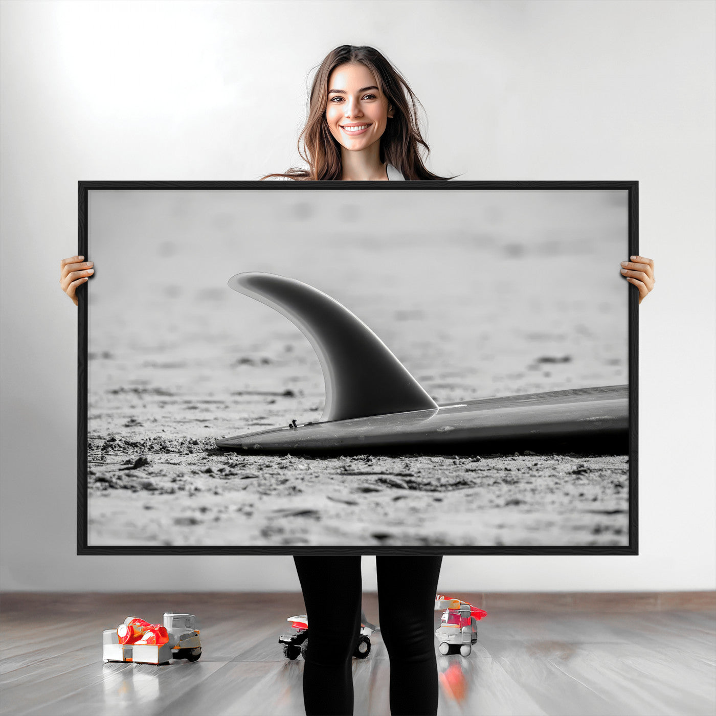 A black and white close-up of a surfboard fin resting on the sandy shore, highlighting minimalist beach aesthetics and classic surf culture.