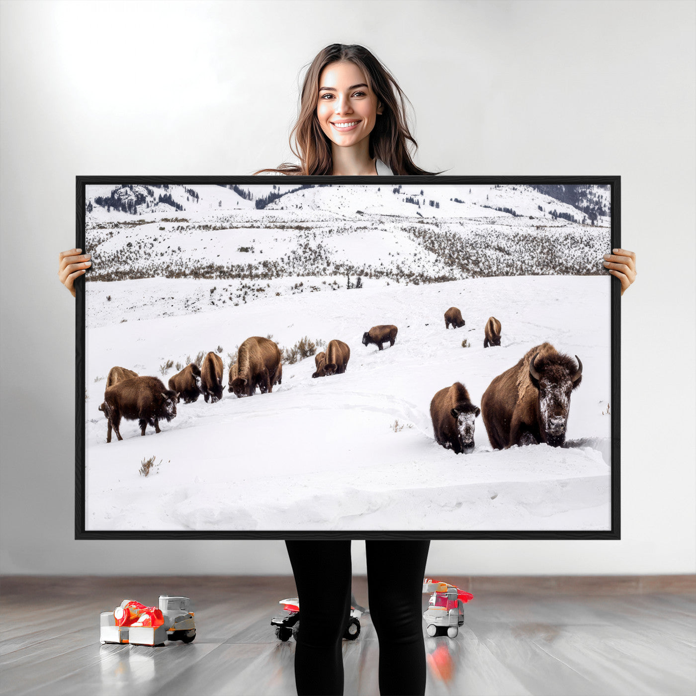 A herd of bison walking through deep snow in a mountain valley, perfect for rustic, cabin or western-themed wall decor.