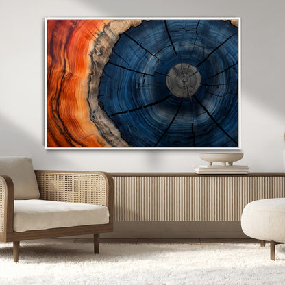 A captivating close-up of a tree trunk, showcasing its concentric rings in rich shades of blue, orange, and brown, highlighting the organic patterns of natural wood.