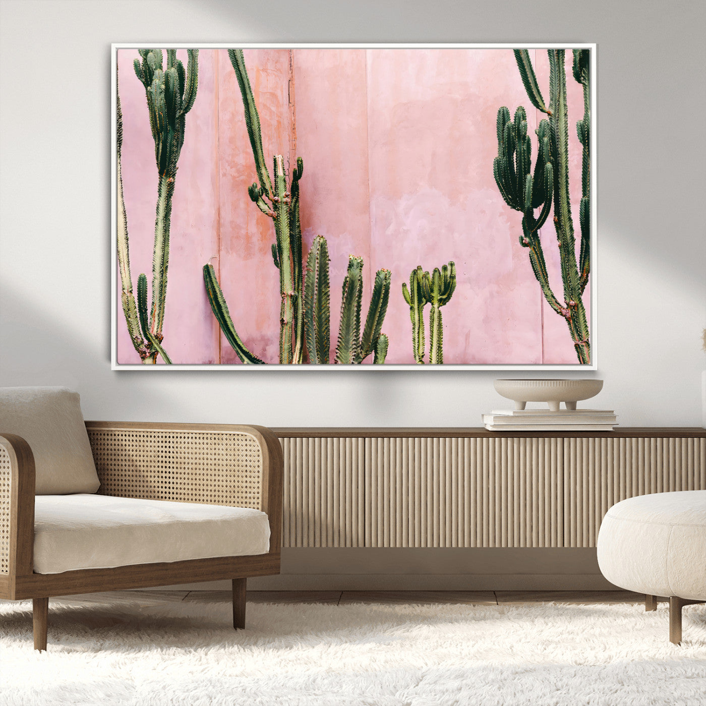 Framed canvas of tall green cacti against a soft pink wall, ideal for modern desert or colorful southwest-inspired home decor.