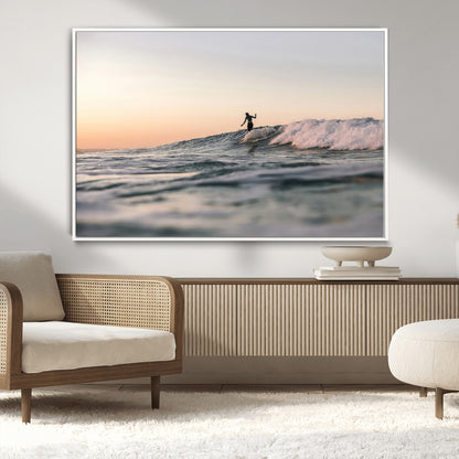 Framed canvas of a female surfer balancing on a wave at sunset, perfect for serene surf or ocean-inspired coastal decor.