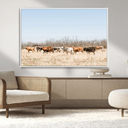 Framed wall art of Texas longhorn cattle walking through a dry, neutral-toned prairie, perfect for rustic farmhouse or western-themed home decor.