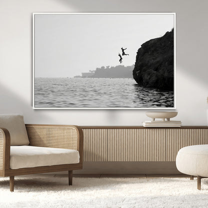 Black and white canvas of two figures cliff jumping into the sea, captured with moody tones, ideal for modern coastal or adventure-themed home decor.   2/2