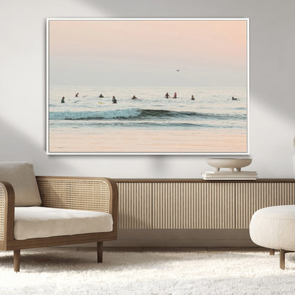 Dreamy photo of surfers waiting on soft pastel waves under a pink sunset sky, ideal for soft coastal minimalist or serene ocean-themed home decor.