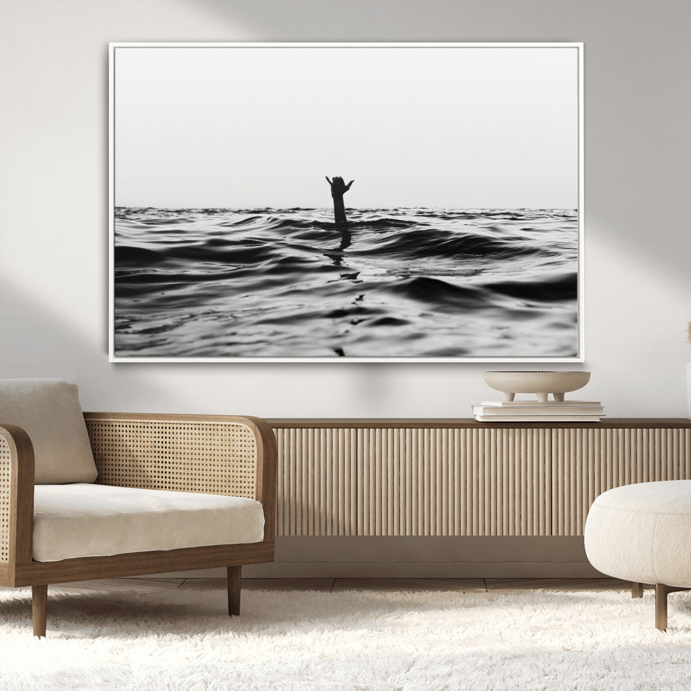 Black and white ocean with a hand making a surfer sign among dark waves, creating a dramatic and minimalist seascape with bold contrast.