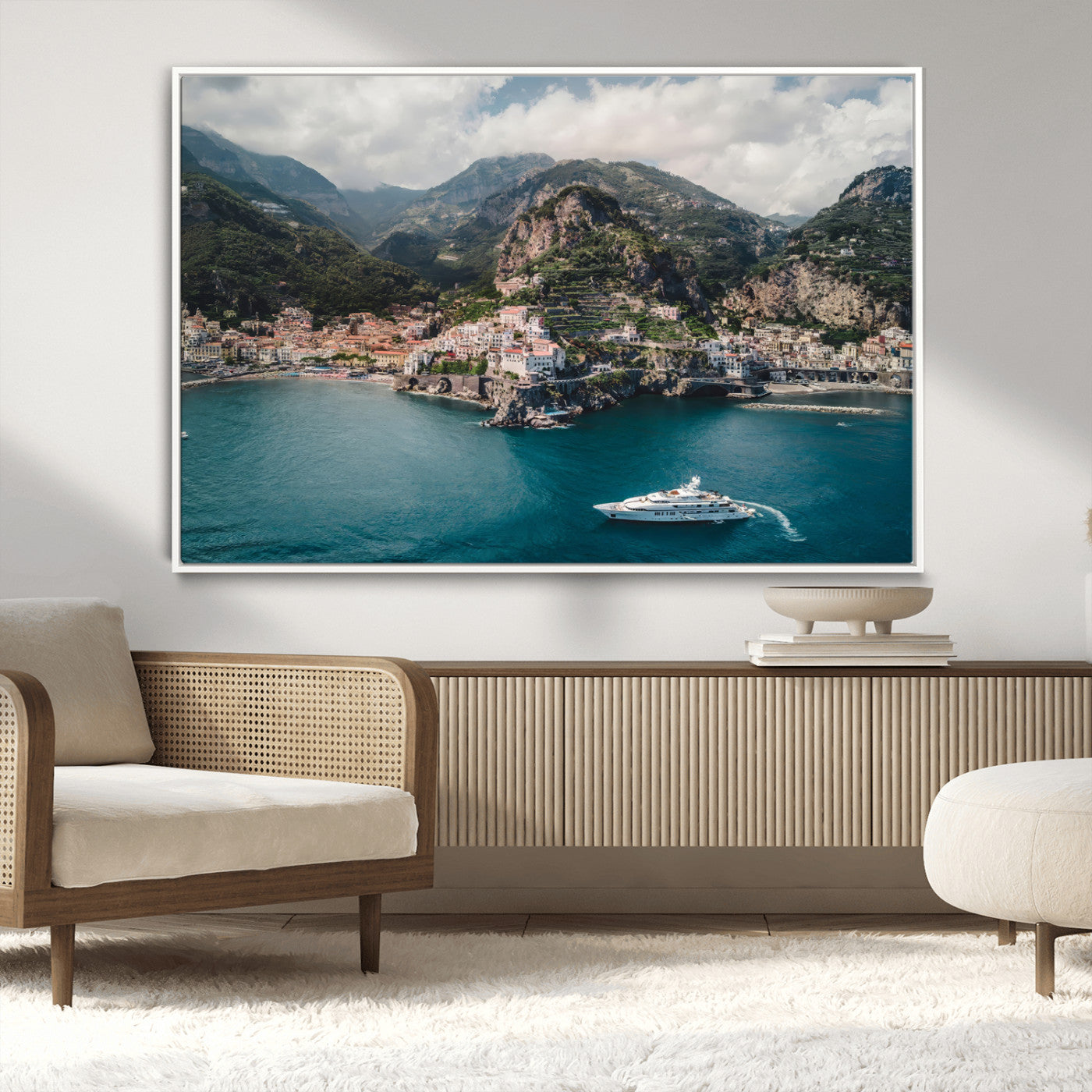 Aerial view of Amalfi Coast, Italy, with colorful hillside houses, lush green mountains, and a luxury yacht sailing in turquoise waters.