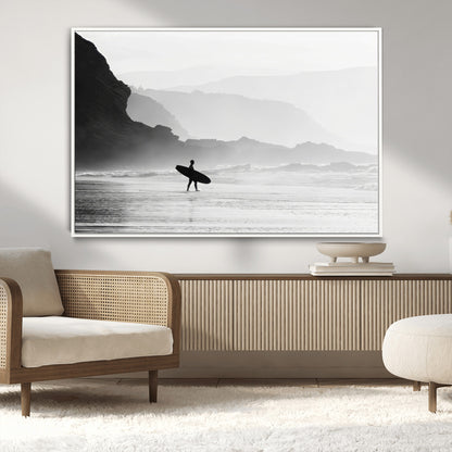 A lone surfer walking along a misty beach with cliffs in the background, carrying their board, capturing a serene and minimal ocean moment.