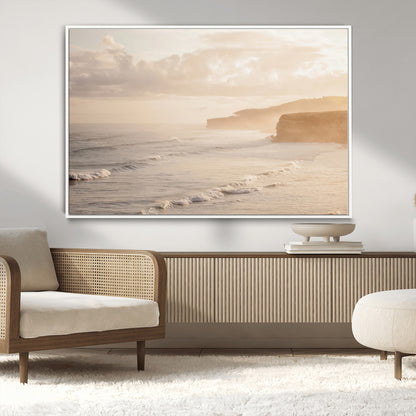 Golden hour seascape with misty cliffs and gentle waves rolling towards the shore, capturing a tranquil and warm coastal atmosphere.