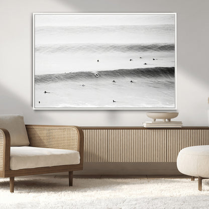 A monochrome photograph of swimmers gliding through gentle ocean waves, evoking a sense of calm and movement.