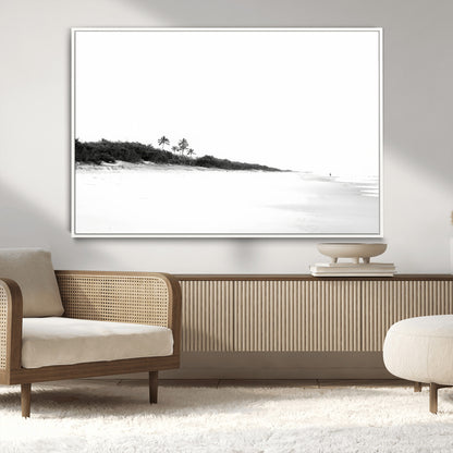 A black and white minimalist coastal scene with a vast open beach, distant palm trees, and a lone figure walking along the shoreline, evoking serenity and solitude.