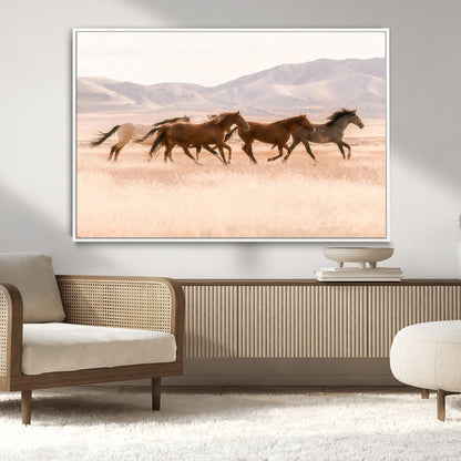 A herd of wild horses galloping through a sunlit desert plain with mountains in the background, perfect for rustic or western-themed wall decor.