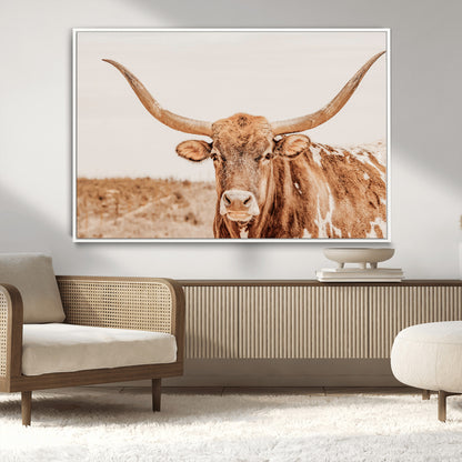 A longhorn bull standing proudly in a sunlit desert field with warm neutral tones, ideal for rustic western or farmhouse interiors.