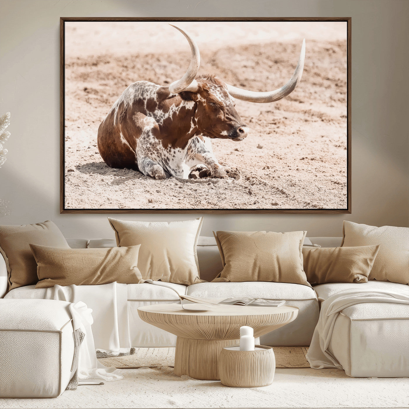 Texas Longhorn bull resting on dusty ground with warm tones, ideal for rustic western or farmhouse-themed wall decor.