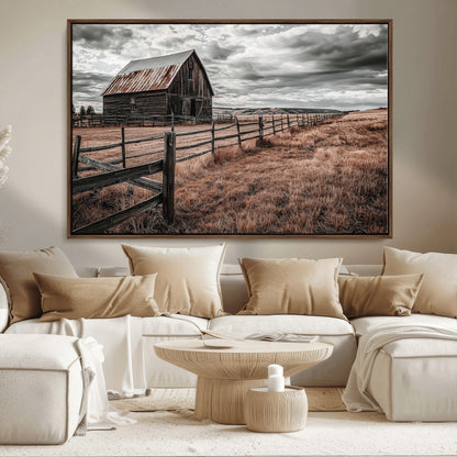 Framed canvas of a rustic barn under a moody sky with weathered fence and dark fields, ideal for farmhouse or rural-style wall decor.