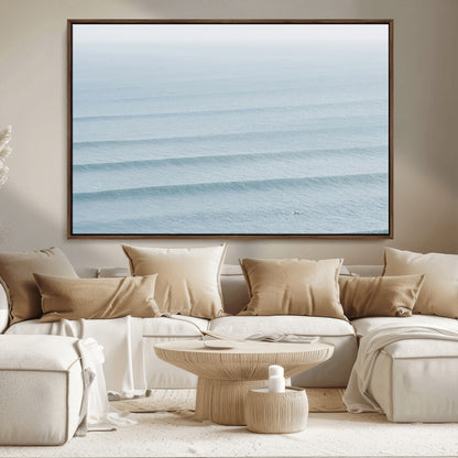 Framed canvas of repeating ocean waves with a distant solo surfer, ideal for minimalist ocean or calm coastal wall decor.