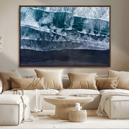 Canvas of aerial ocean waves crashing onto a black sand beach in moody tones, ideal for modern coastal or minimalist home decor.