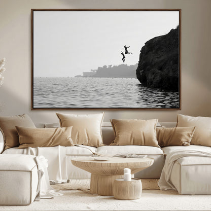 Black and white canvas of two figures cliff jumping into the sea, captured with moody tones, ideal for modern coastal or adventure-themed home decor.   2/2