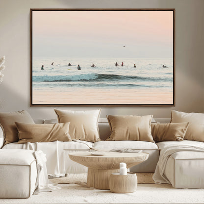 Dreamy photo of surfers waiting on soft pastel waves under a pink sunset sky, ideal for soft coastal minimalist or serene ocean-themed home decor.
