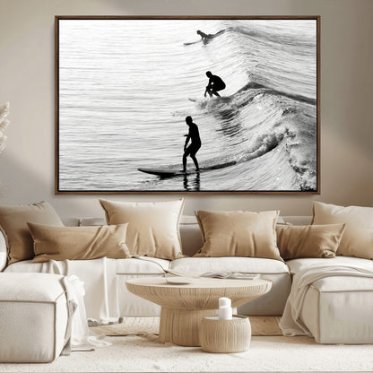 Black and white photo of surfers riding waves in a moody, high-contrast scene, ideal for modern coastal or surf-inspired home decor.