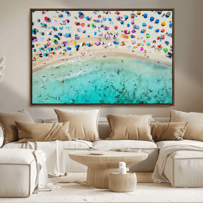 Aerial view of a vibrant beach filled with colorful umbrellas and people enjoying the turquoise ocean, capturing a lively summer vacation scene.