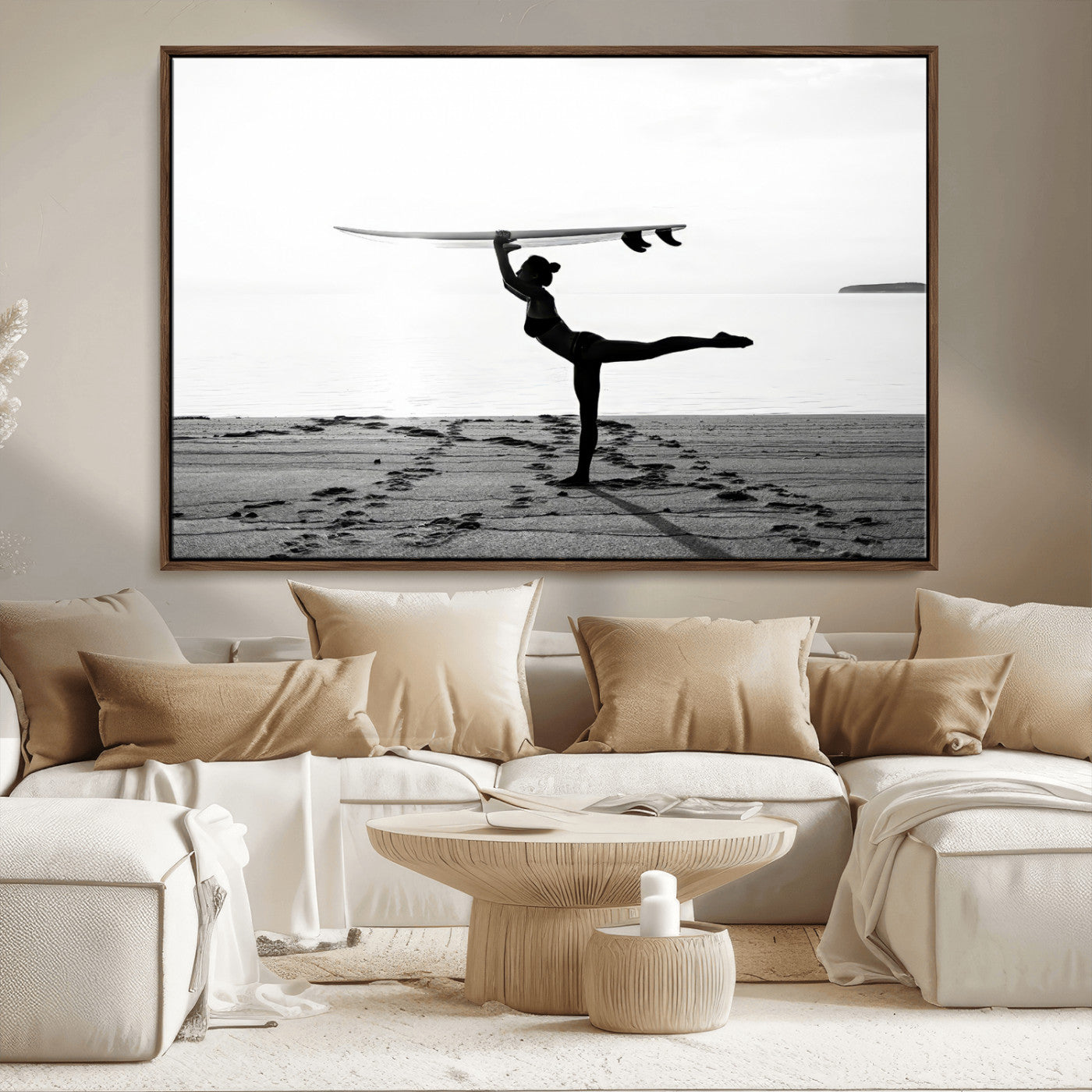 A woman balances a surfboard on her head while striking a yoga pose on the beach, silhouetted against a calm ocean horizon.