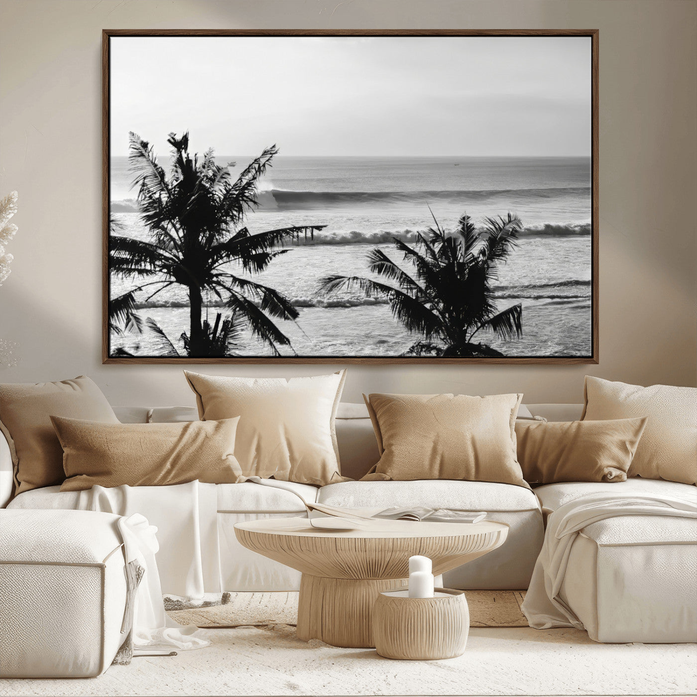 Black and white view of ocean waves crashing on a tropical coastline, framed by silhouetted palm trees under a vast, open sky.