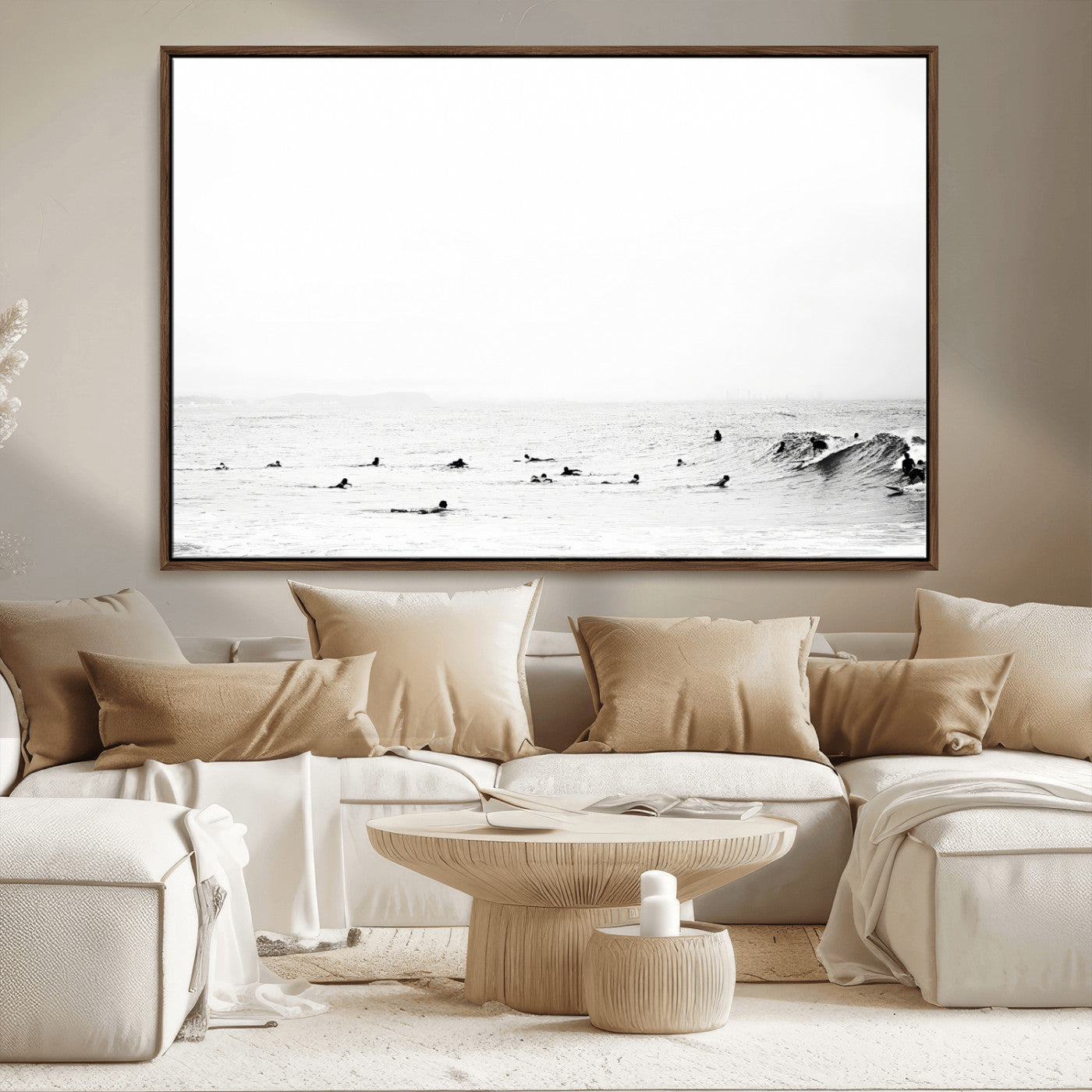 A group of surfers floating in the ocean, waiting for waves under a vast, moody sky, captured in black and white.