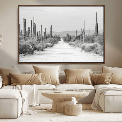 A black and white desert road stretching through a cactus-filled landscape, creating a rugged and timeless southwestern aesthetic with a sense of adventure.