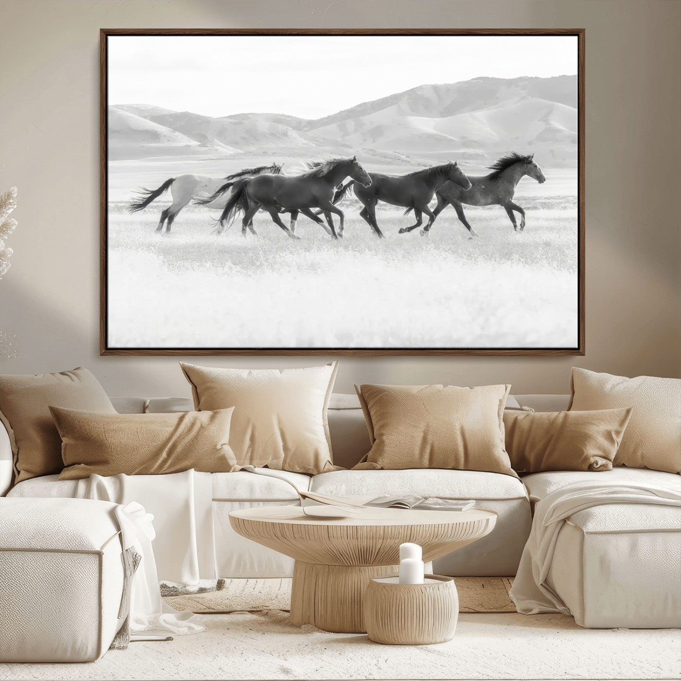 A black and white image of wild horses running freely across an open grassland, capturing the power and beauty of untamed nature in a rustic western setting.