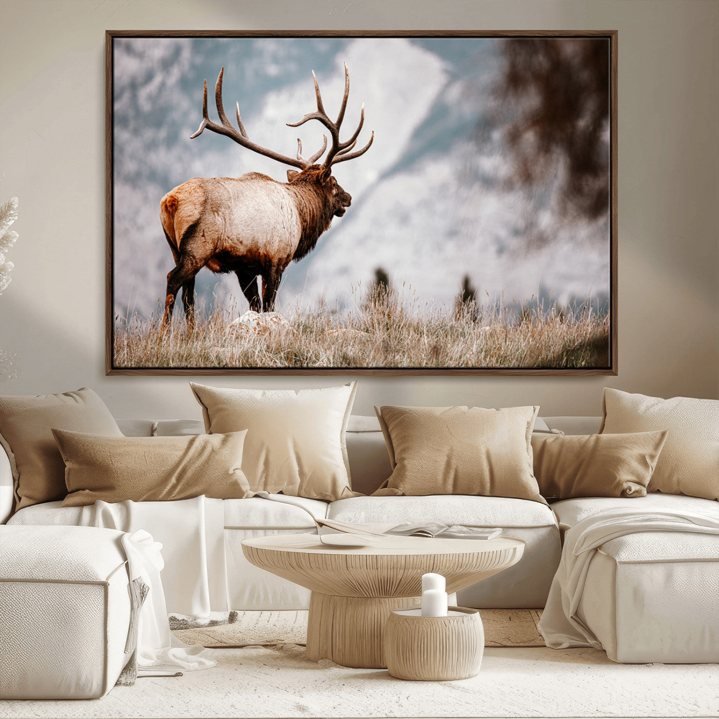 Majestic elk with large antlers standing in grass with snowy mountains in background, perfect for rustic cabin or lodge style decor.