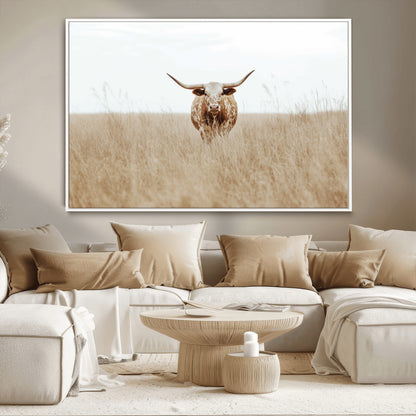 Texas Longhorn bull standing alone in dry grass with neutral tones, ideal for rustic western or cowboy-themed wall decor.