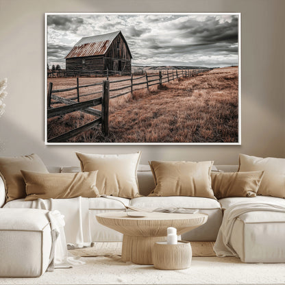 Framed canvas of a rustic barn under a moody sky with weathered fence and dark fields, ideal for farmhouse or rural-style wall decor.