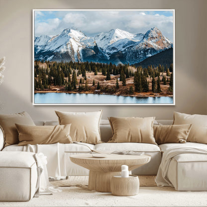 Framed canvas of snowy mountain peaks with pine forest and alpine lake, perfect for winter cabin or wilderness-inspired home decor.