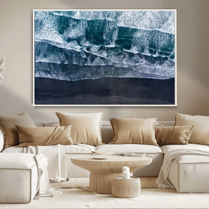 Canvas of aerial ocean waves crashing onto a black sand beach in moody tones, ideal for modern coastal or minimalist home decor.