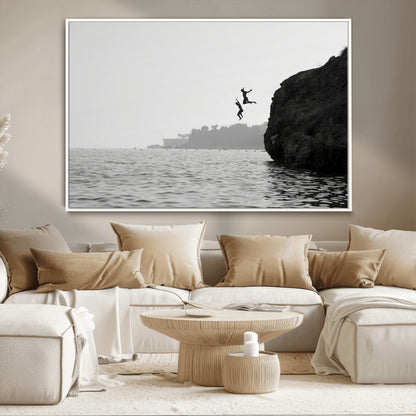 Black and white canvas of two figures cliff jumping into the sea, captured with moody tones, ideal for modern coastal or adventure-themed home decor.   2/2