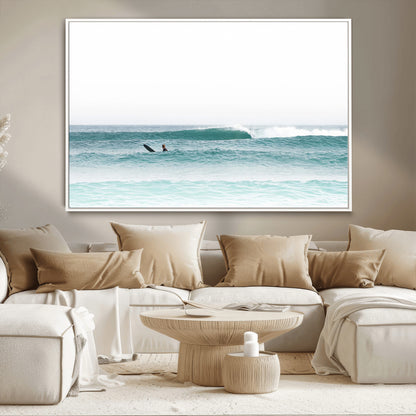 Minimalist photo of a lone surfer on calm aqua waves under bright sky, perfect for Scandinavian coastal or serene ocean-inspired home decor.