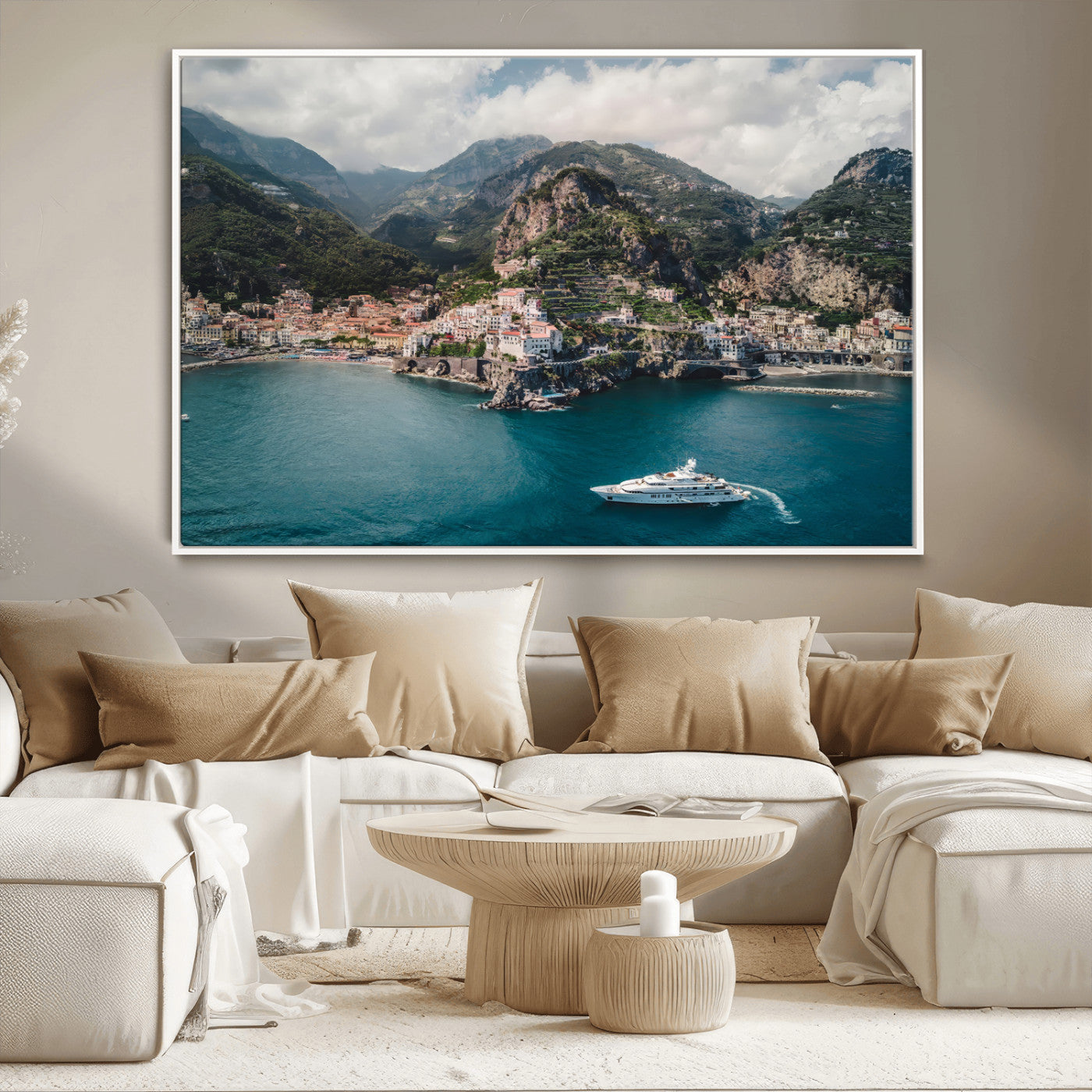 Aerial view of Amalfi Coast, Italy, with colorful hillside houses, lush green mountains, and a luxury yacht sailing in turquoise waters.