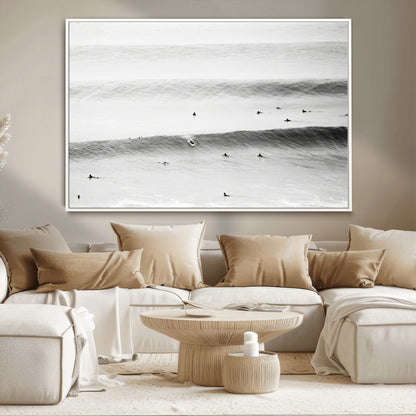 A monochrome photograph of swimmers gliding through gentle ocean waves, evoking a sense of calm and movement.