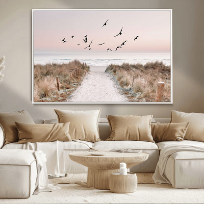 A peaceful coastal pathway leading to the ocean, with birds flying across a soft pastel sky, creating a calm and scenic beach atmosphere.