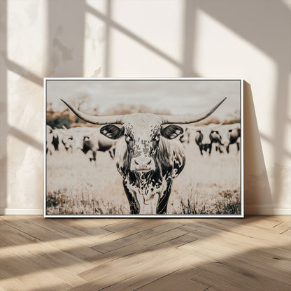 Canvas of a speckled Texas longhorn standing boldly in a field with a herd behind, perfect for rustic western or farmhouse wall decor.