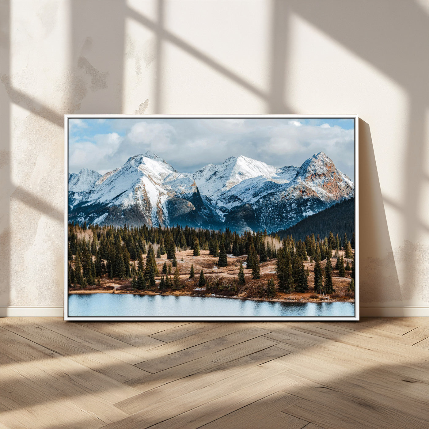 Framed canvas of snowy mountain peaks with pine forest and alpine lake, perfect for winter cabin or wilderness-inspired home decor.