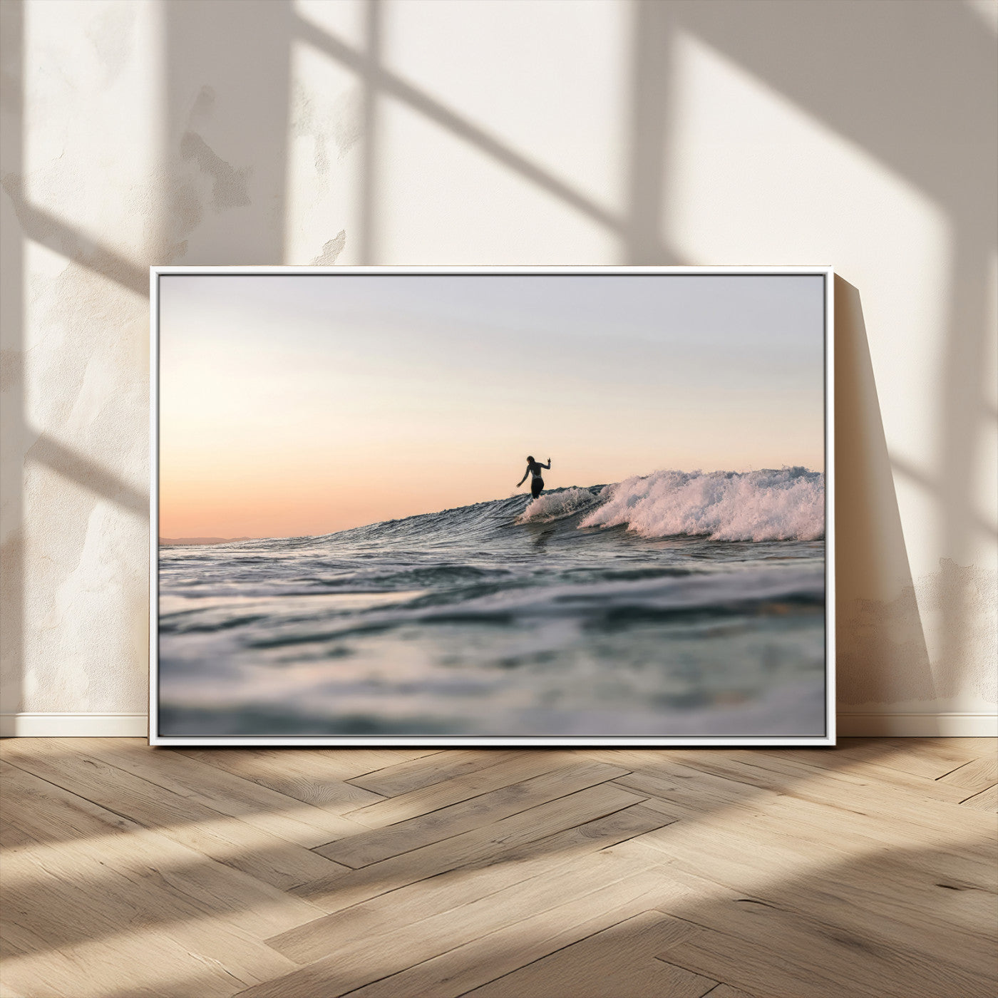 Framed canvas of a female surfer balancing on a wave at sunset, perfect for serene surf or ocean-inspired coastal decor.