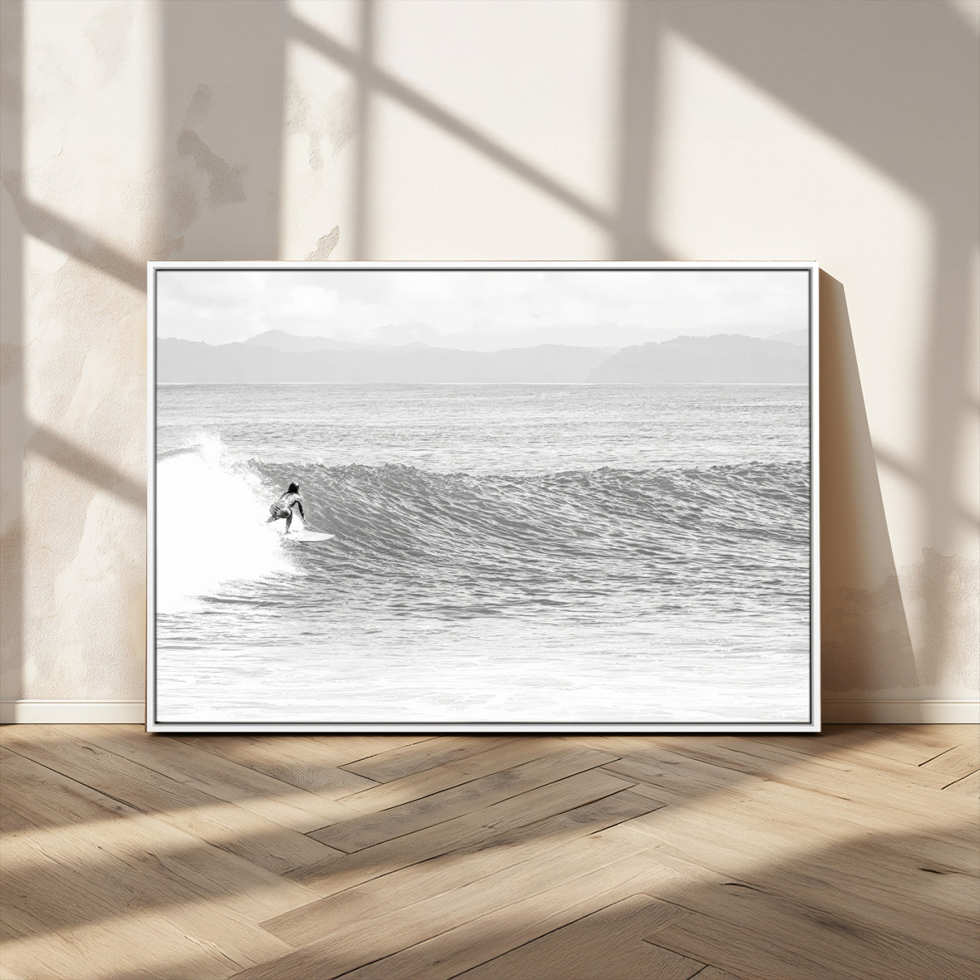 Monochrome photo of a surfer riding a wave with distant mountains, ideal for coastal motion or black and white surf-themed wall decor.