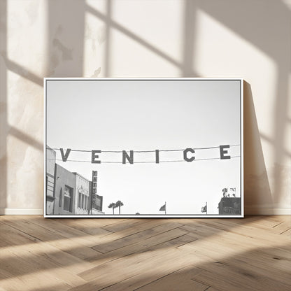 Black and white photo of Venice Beach sign and palm-lined street, perfect for urban coastal or minimalist LA-inspired wall decoration.