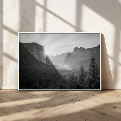 Black and white landscape of Yosemite with sun rays peeking over El Capitan, ideal for moody nature or modern rustic decor.