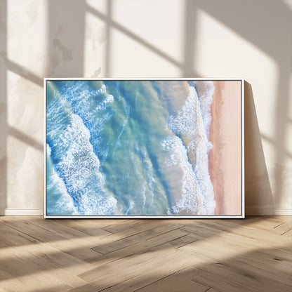 Aerial photo of soft blue waves meeting sandy shore, perfect for modern coastal or beach-themed decor with a light and tranquil aesthetic.
