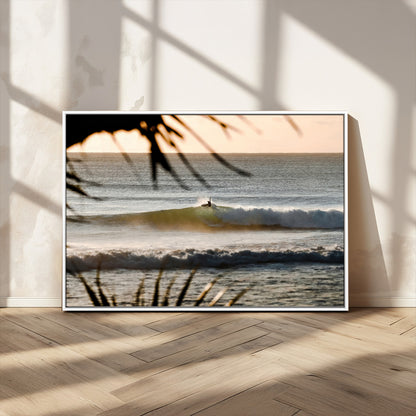 Photo of a surfer riding a golden hour wave at sunset, with tropical tones and dreamy light, perfect for tropical boho or coastal home decor.